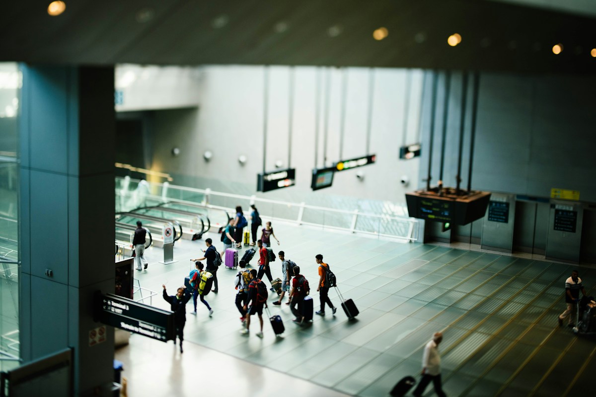 Travellers with luggage crossing an airport terminal